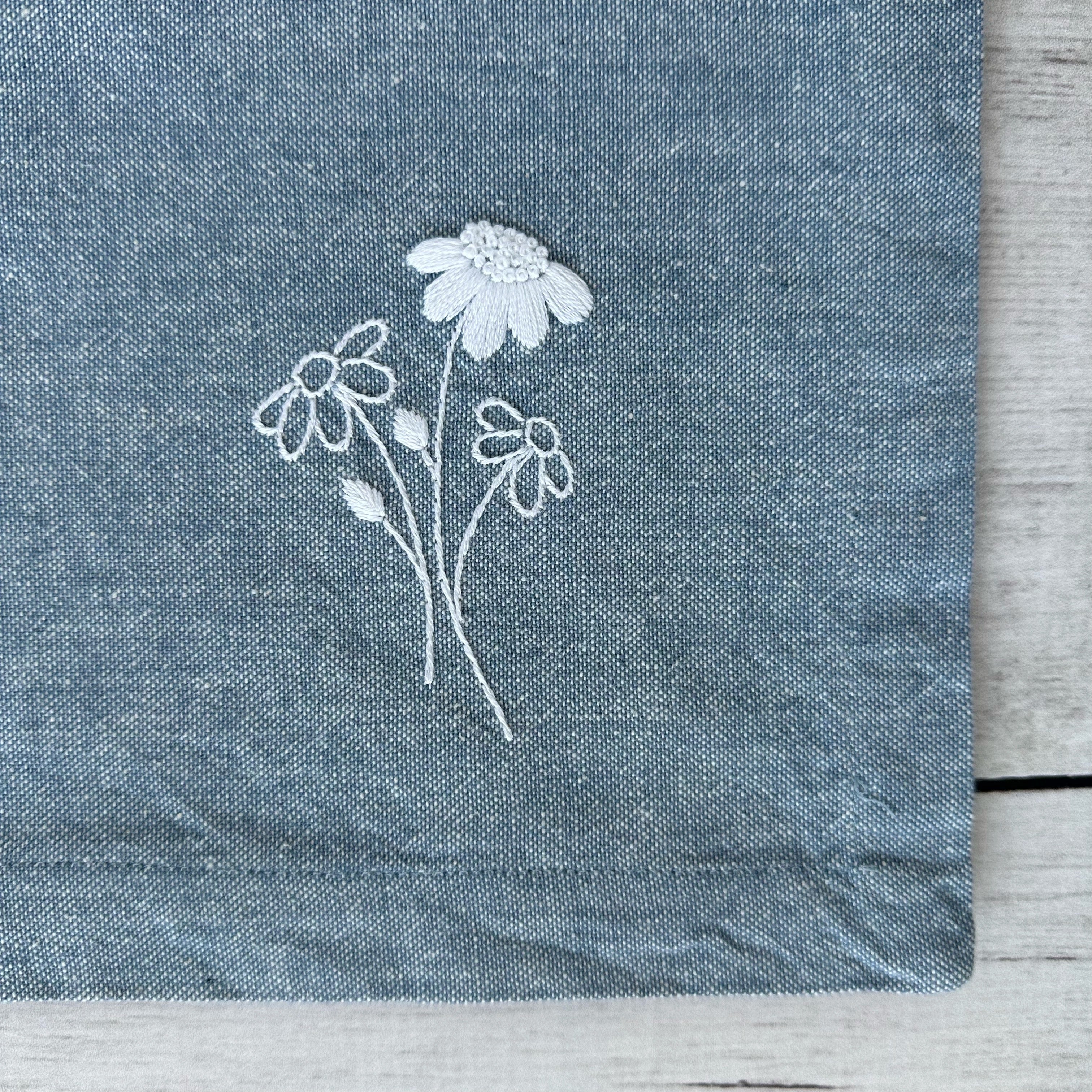 Embroidered flowers on a blue cotton napkin corner