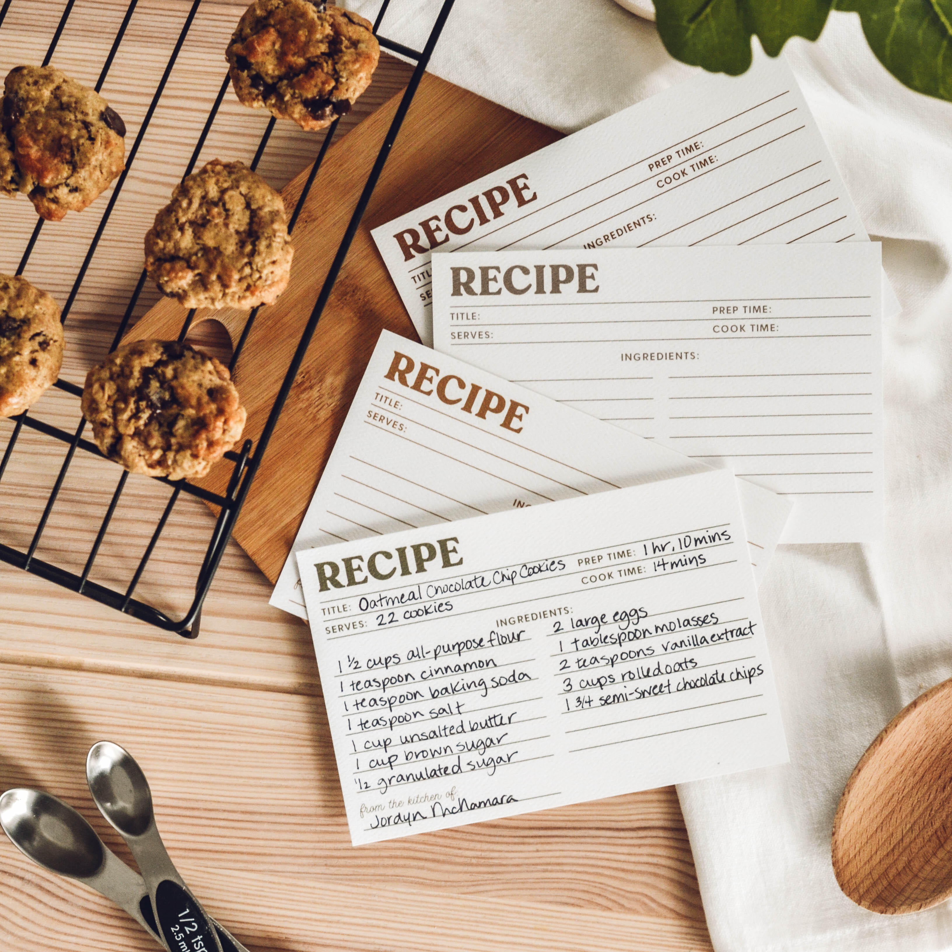 Recipe cards with a batch of cookies on a cooling rack.