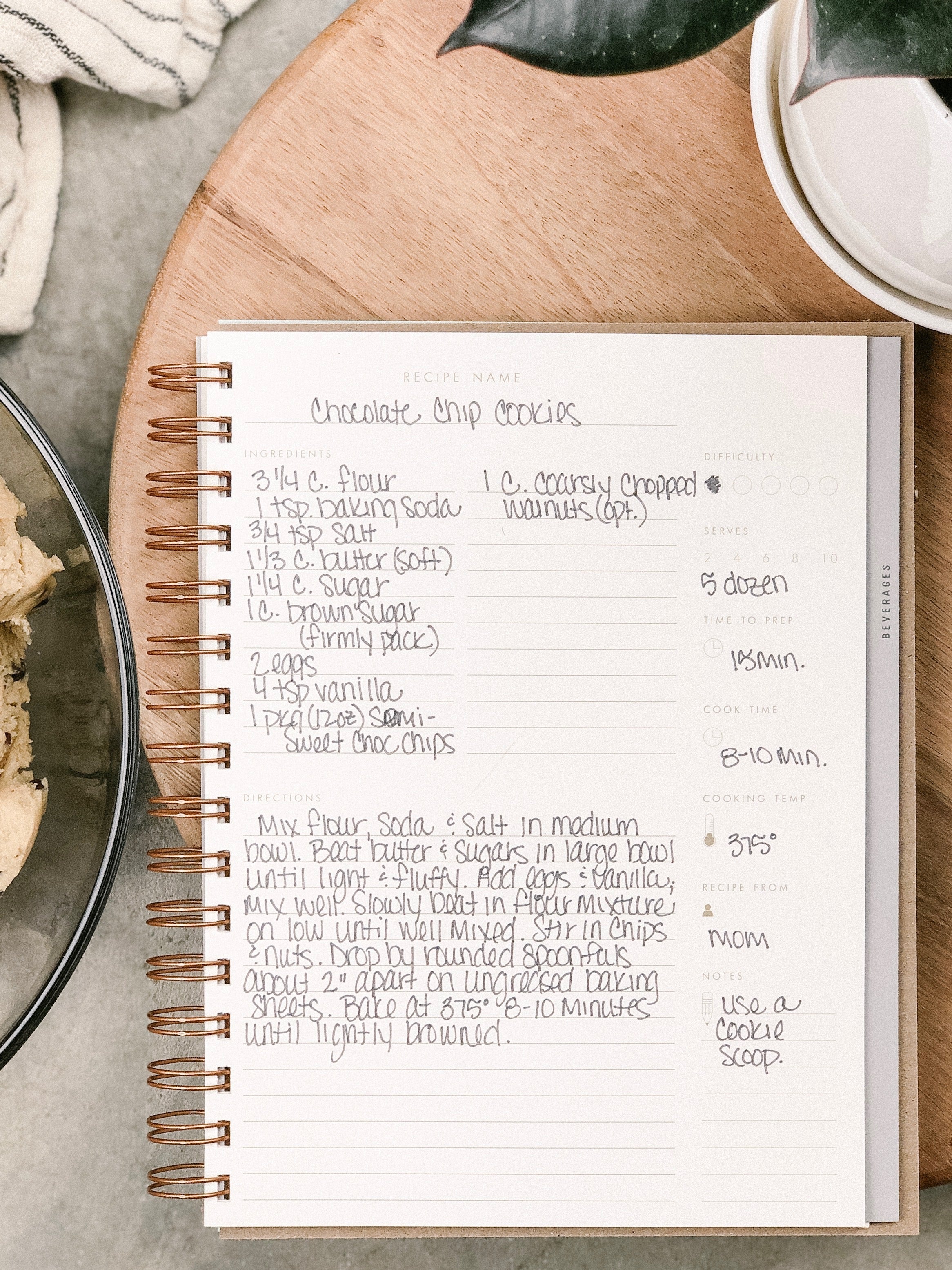 Recipe book open to a chocolate chip cookies recipe on a kitchen counter.