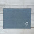 Blue cotton placemat with embroidered floral design on a wooden surface