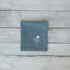 Blue cotton napkin with floral embroidered design on a wooden surface
