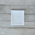 White cotton napkin with floral embroidered design on a wooden surface