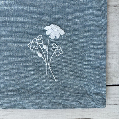 Embroidered flowers on a blue cotton napkin corner