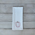 White tea towel with embroidered red bell pepper design on a wooden surface
