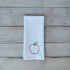 White tea towel with an embroidered red apple design on a wooden surface