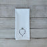 White tea towel with embroidered beet design on a wooden surface