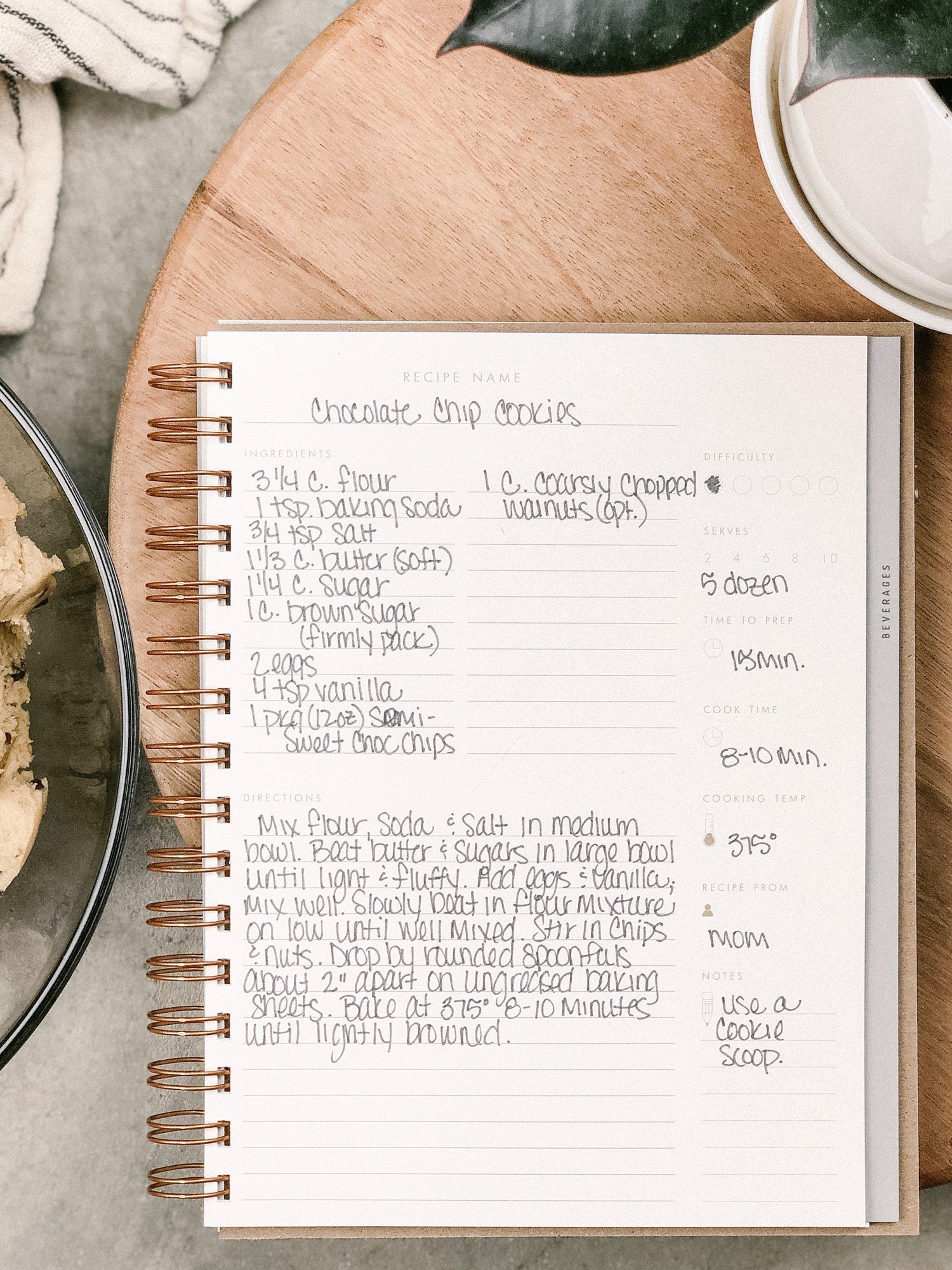 Recipe book open to a chocolate chip cookies recipe on a kitchen counter.