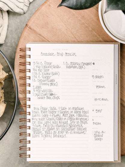 Recipe book open to a chocolate chip cookies recipe on a kitchen counter.